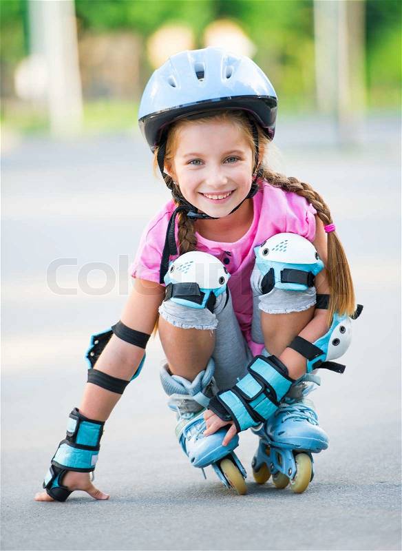 Little girl on roller skates at park, stock photo