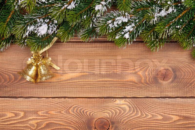 Christmas fir tree with snow and holiday decor on rustic wooden board with paper for copy space, stock photo