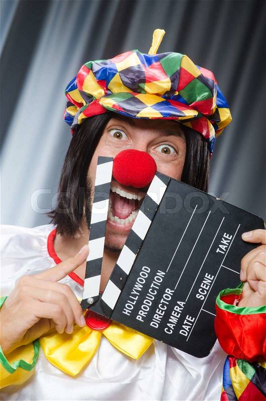 Clown with movie clapper board, stock photo