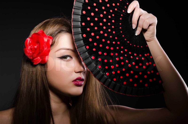 Beautiful young woman with flower and fan, stock photo