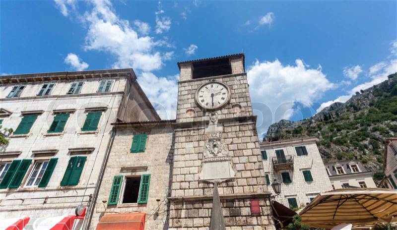 High stone tower clock in city of Kotor, Montenegro, stock photo