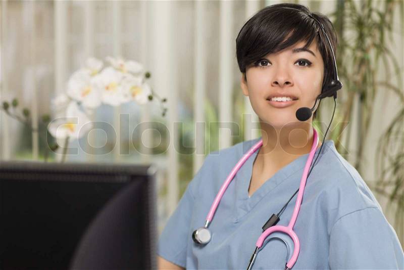 Attractive Mixed Race Young Woman Nurse Practitioner or Doctor at Her Computer Monitor, stock photo