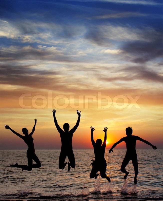 Silhouette of jumping people on sunset background, stock photo