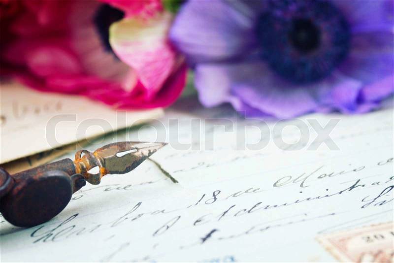 Old retro golden quill pen and antique letters with flowers, stock photo