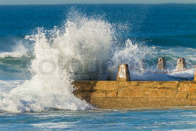 Large ocean waves white water crashing into beach tidal pool, stock photo