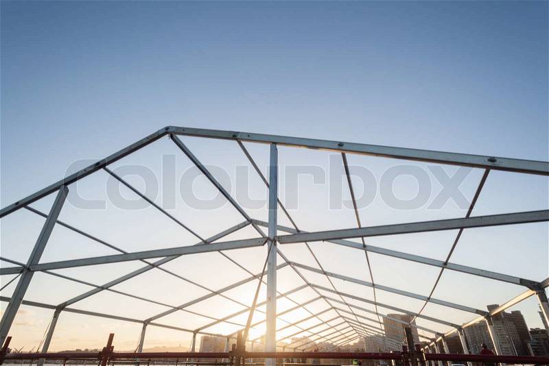 Metal alloy structure of tent frame open to blue sky, stock photo