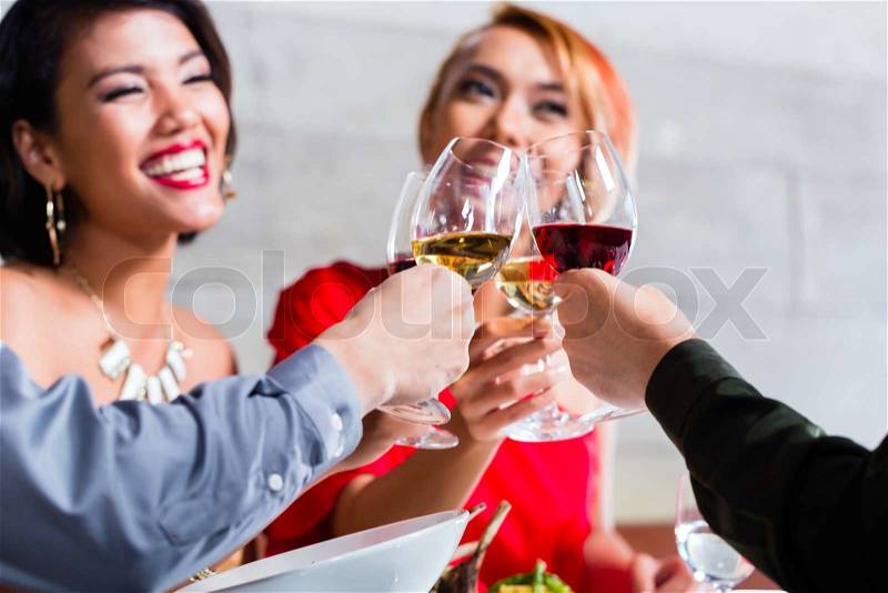 Asian friends, two couples, dining in fancy restaurant eating good food and drinking wine, stock photo