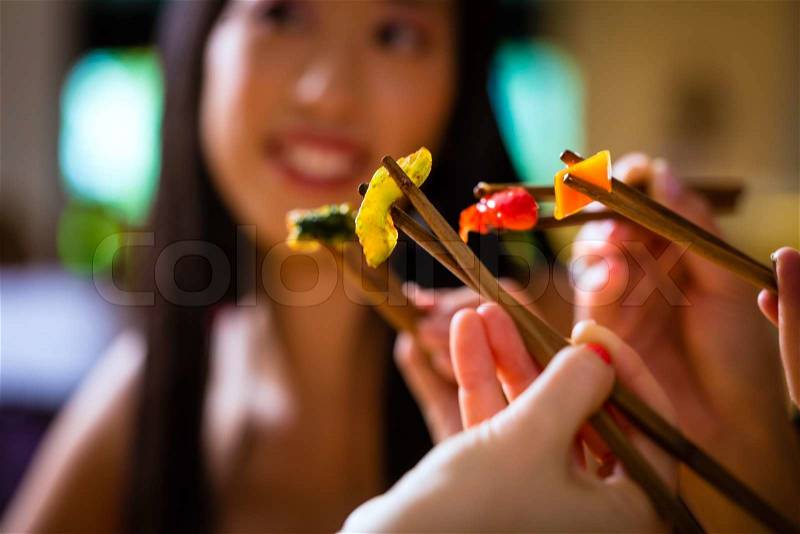 Young people eating in Asia restaurant, stock photo