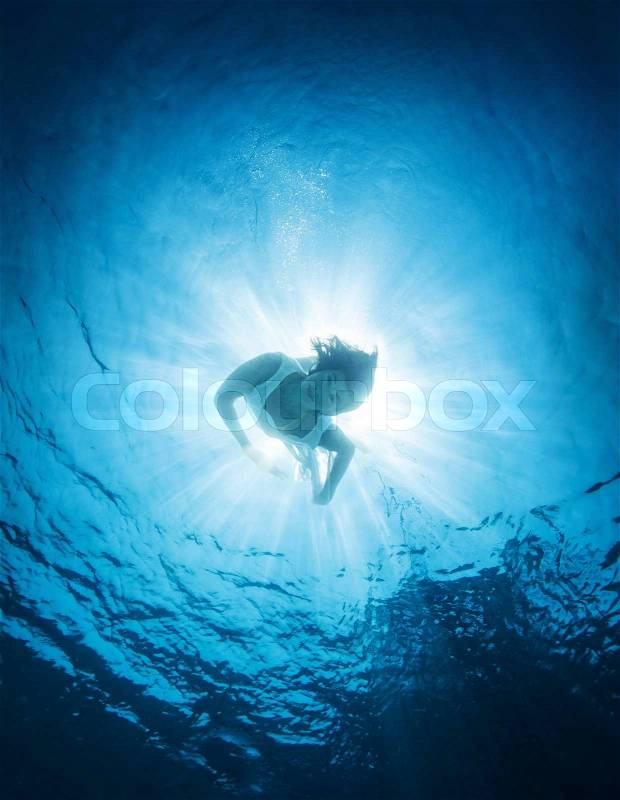 Woman dive into the sea, active lifestyle, swimming in transparent blue water, discovering nature, summer vacation concept, stock photo