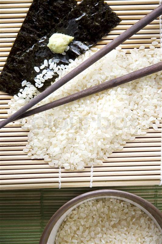 Japanese rice with chopsticks on bamboo mat, stock photo