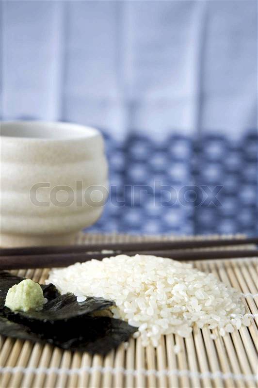 Raw japanese rice on bamboo mat, stock photo