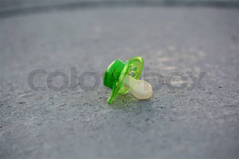 Lost pacifier on a footpath in a town, stock photo