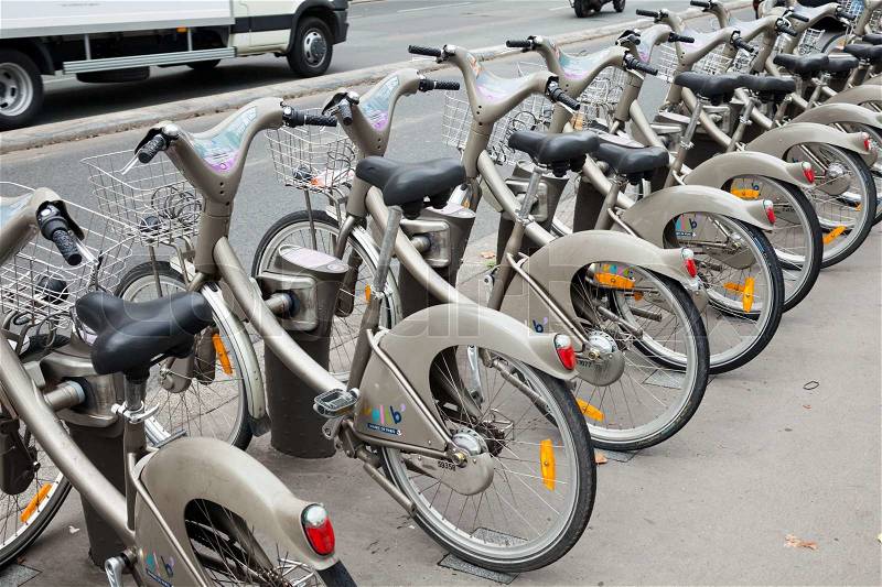 PARIS, FRANCE - AUGUST 07, 2014: Row of gray city public bicycles for rent standing on the parking lot, stock photo