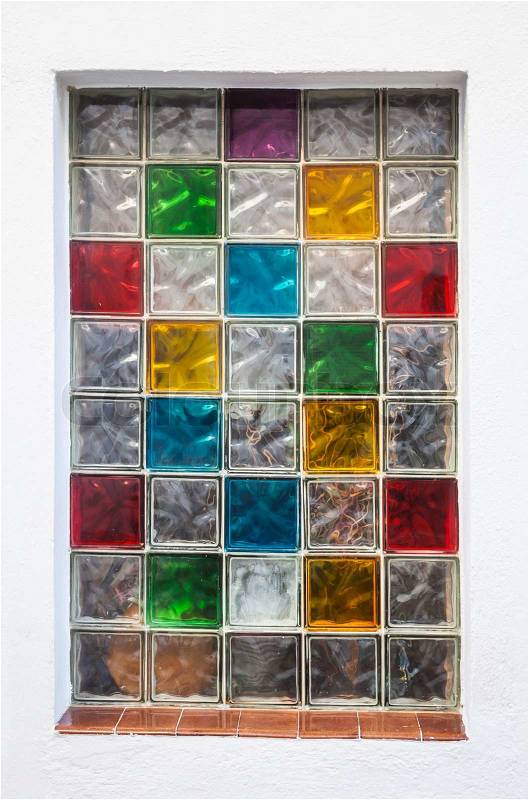Colorful window glass blocks in white wall. Abstract background texture, stock photo