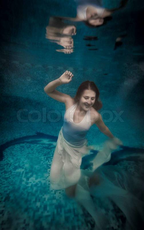 Scared woman in long white dress drowning at deep swimming pool, stock photo