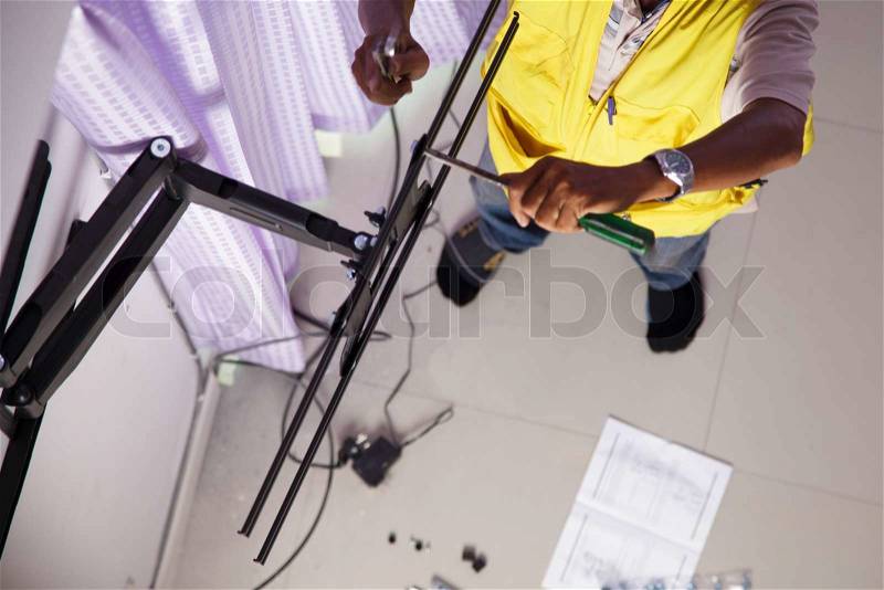 Man installing mount TV on the wall at home, stock photo