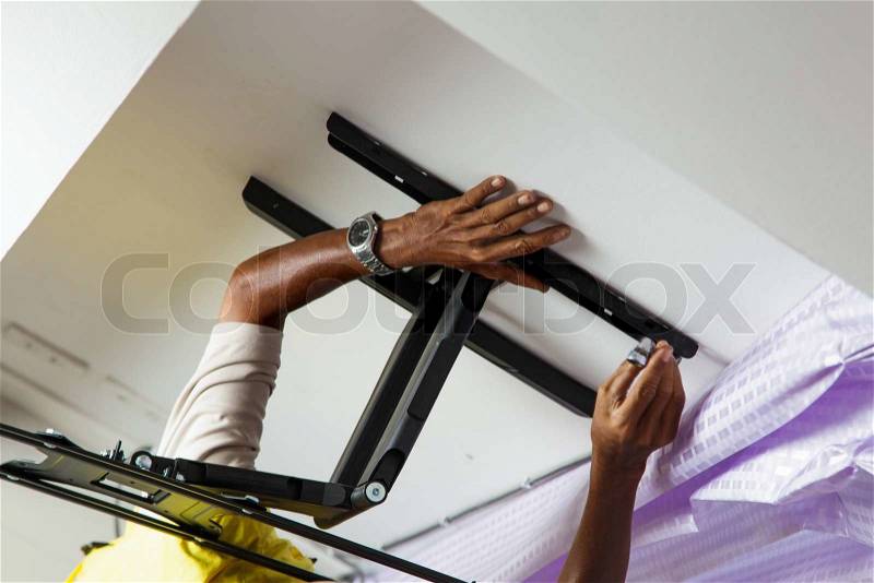 Man installing mount TV on the wall at home, stock photo