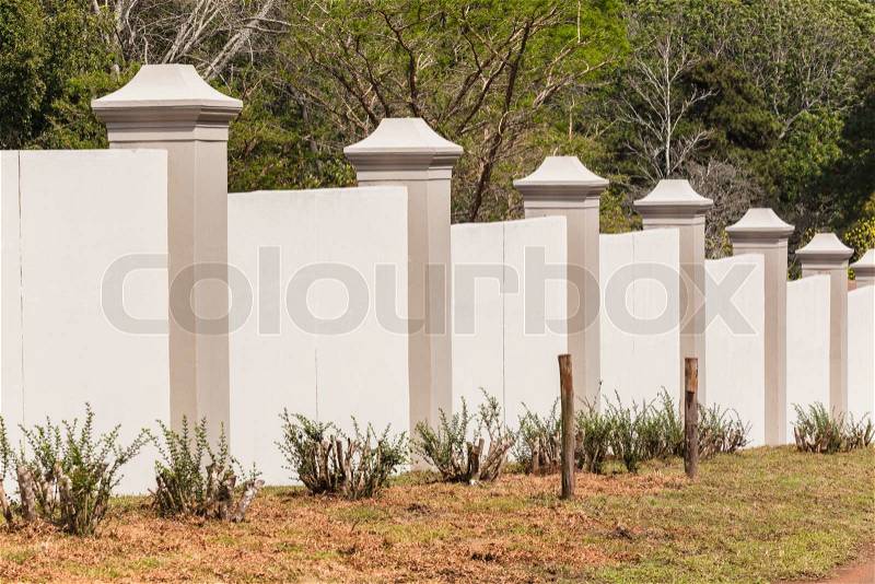 Boundary wall new designed constructiion detail with tree grass vegetation in countryside, stock photo