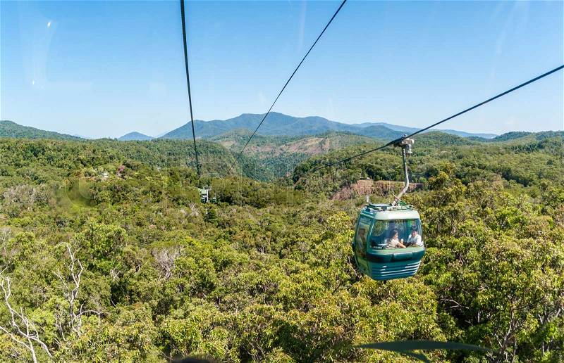 Cable car with tourists suspended travels high over tropical rain forest roof at Kuranda Cairns, stock photo
