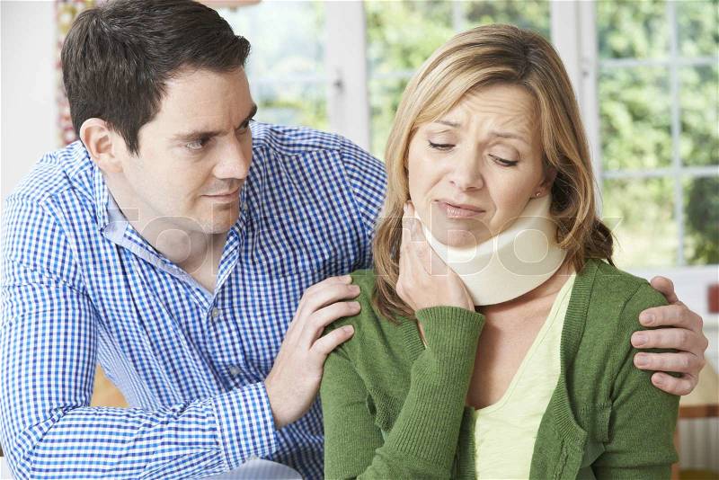Husband Comforting Wife Suffering With Neck Injury, stock photo