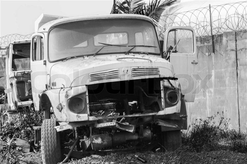 Trucks abandoned stripped bare broken industrial vehicles in black and white vintage contrasts, stock photo