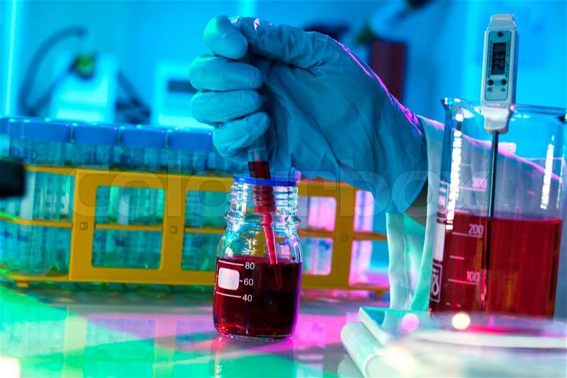 Researchers work in modern scientific lab. Preparation of hazardous solution, stock photo
