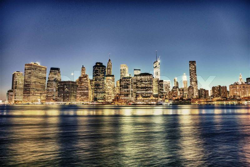 New York City. Delightful Manhattan downtown skyline at dusk with skyscrapers illuminated over East River panorama, stock photo