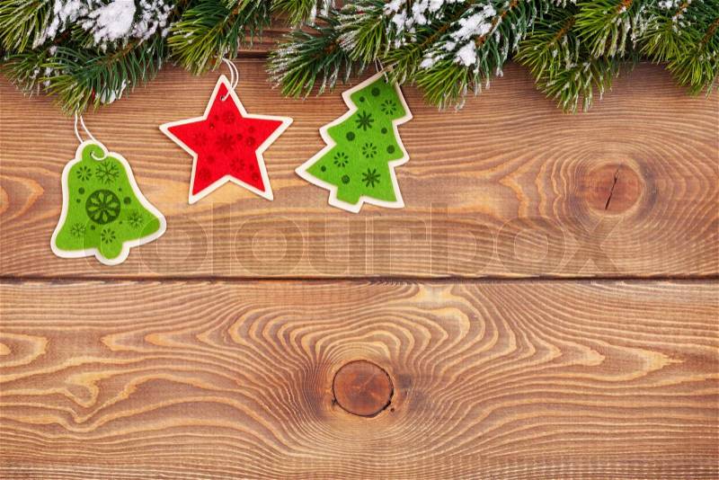Christmas fir tree with snow and holiday decor on rustic wooden board with copy space, stock photo
