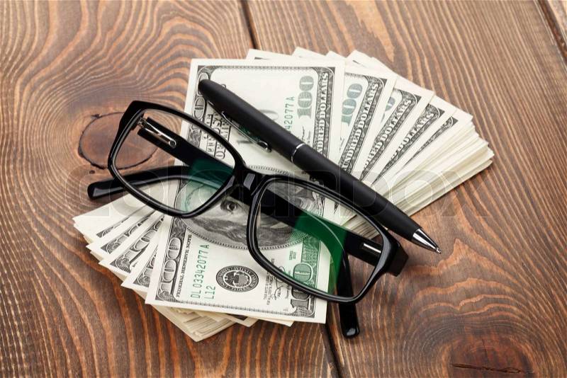 Money, glasses and pen on wooden table, stock photo