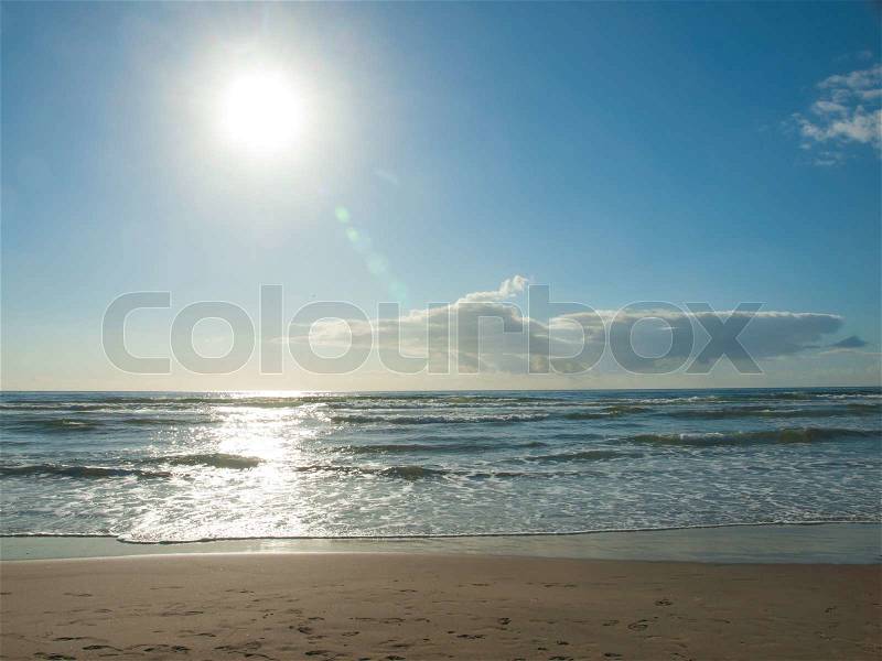 Blue Ocean Waves Breaking on the Beach as the Sun is Going Down, stock photo