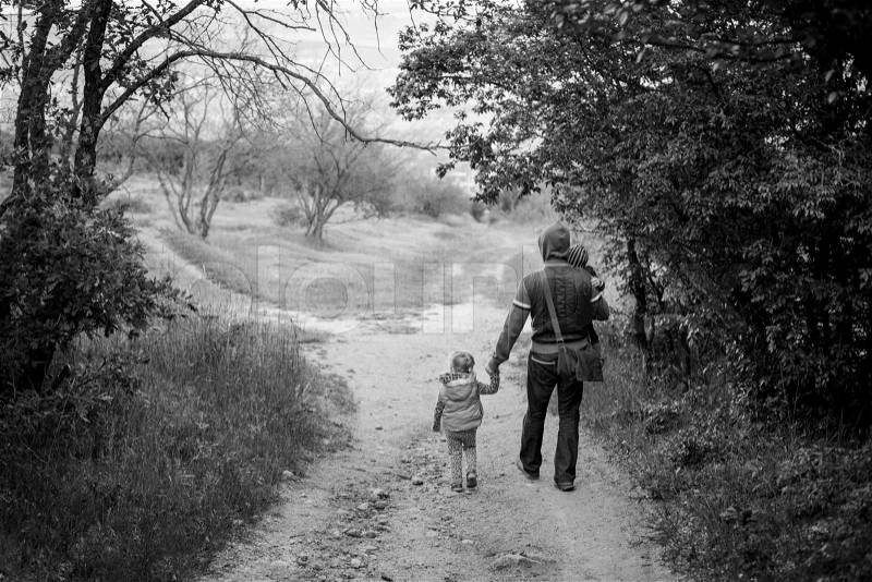 Father with young daughter and son walking in forest ( black and white ), stock photo