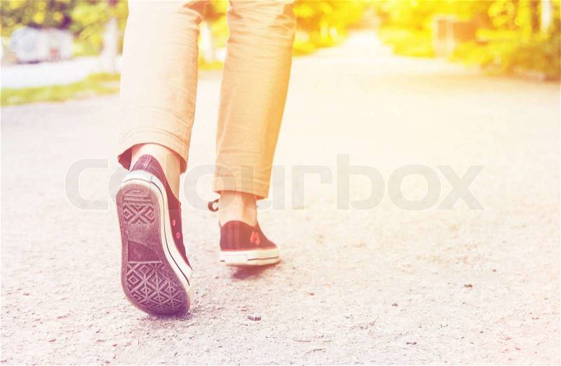 Sunny woman legs gumshoes walk, stock photo