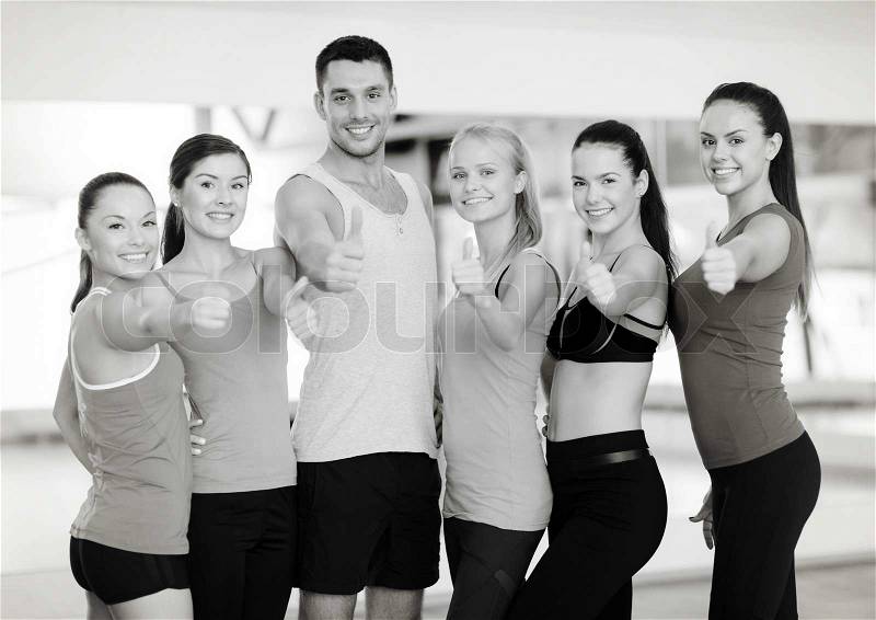 Fitness, sport, training, gym and lifestyle concept - group of happy people in the gym showing thumbs up, stock photo