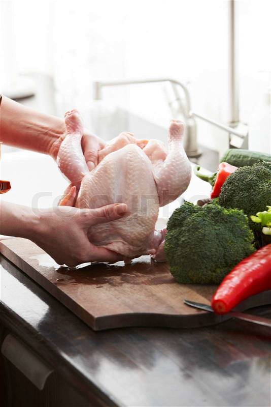 A female hands preparing chicken in the kitchen, stock photo