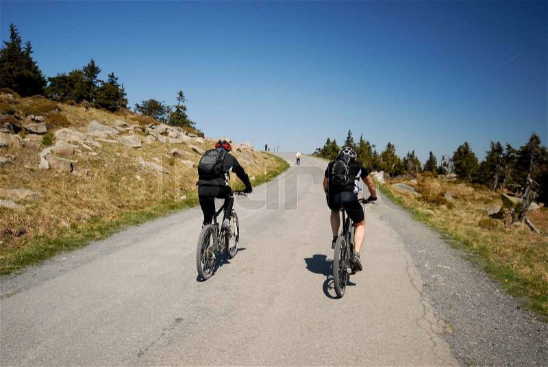 Two Men on Mountain Bikes riding uphill on Brocken in Harz, Germany, stock photo