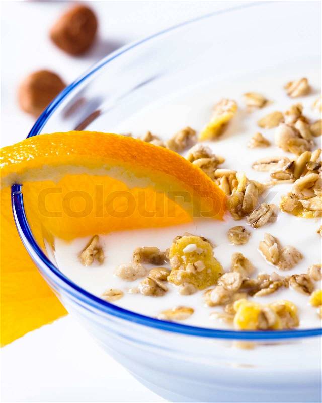 Why not start the day with some healthy orange flavoured yoghurt with nuts and cereal, stock photo
