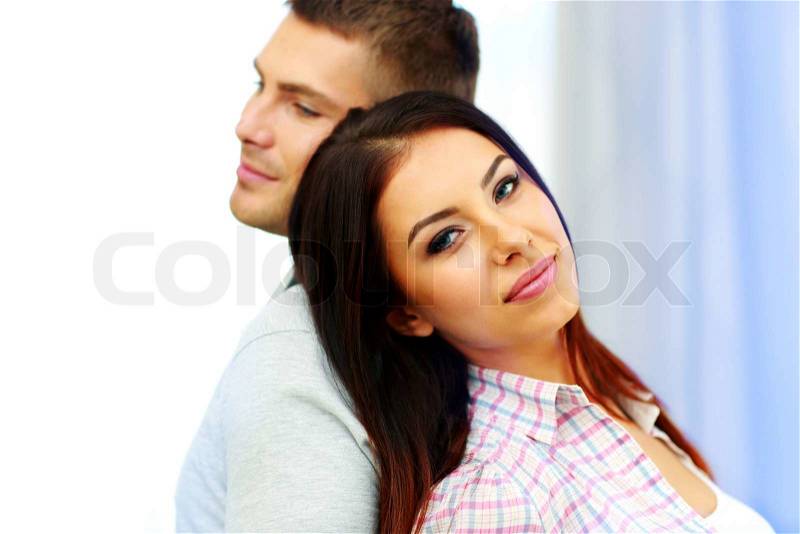 Portrait of a young couple standing back to back, stock photo