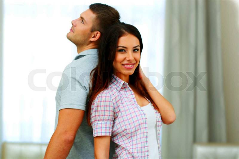 Portrait of a beautiful couple standing back to back, stock photo