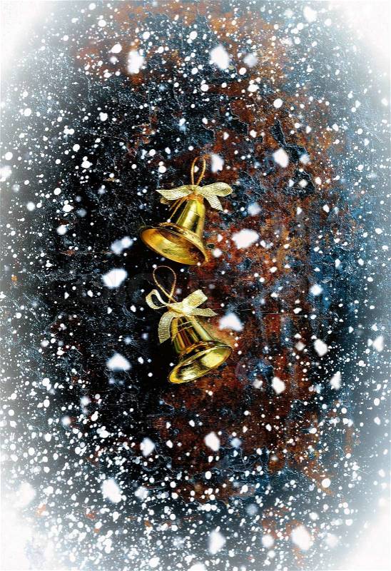 Christmas bells on a dark vintage background with snowfall, stock photo