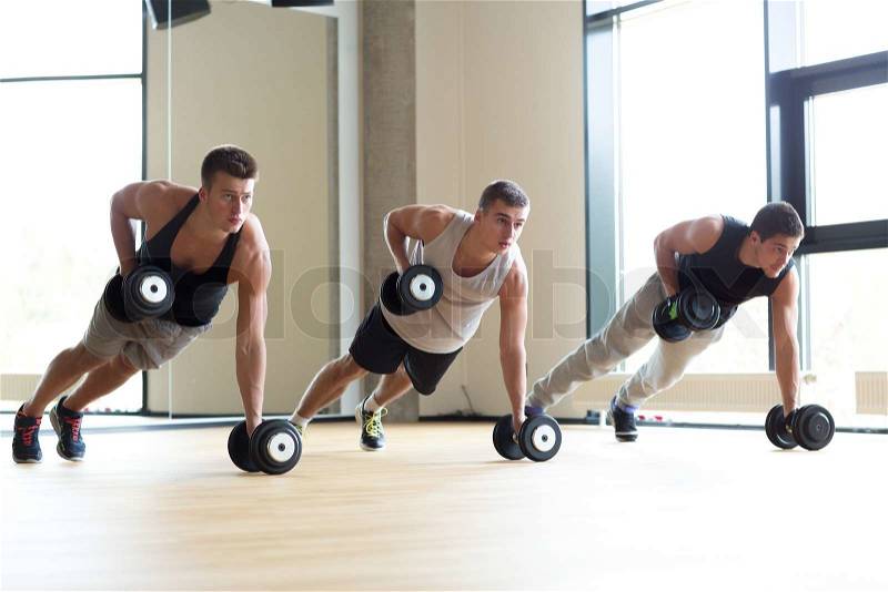 Sport, fitness, lifestyle and people concept - group of men with dumbbells in gym, stock photo