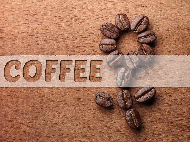 Coffee crop beans on wood texture background, stock photo
