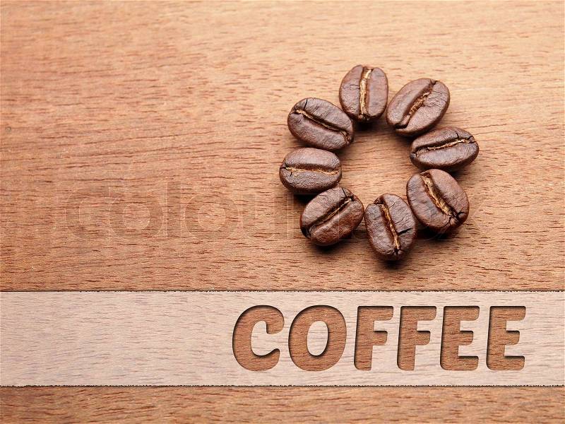 Coffee crop beans with text paper on wood texture, stock photo