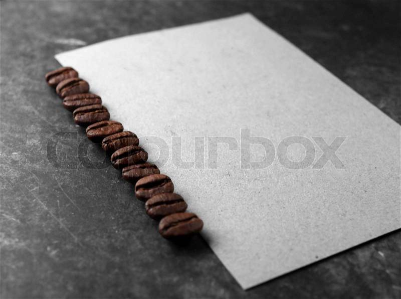 Coffee crop beans with paper on wood texture background, stock photo
