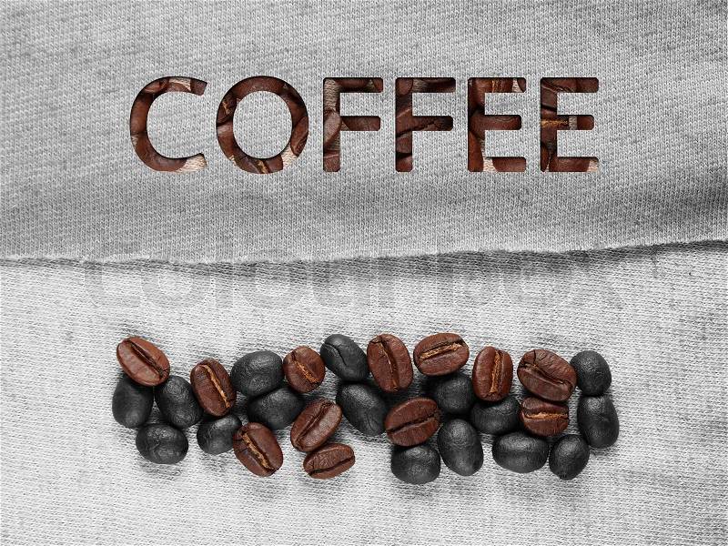 Coffee crop beans on fabric textile texture background, stock photo