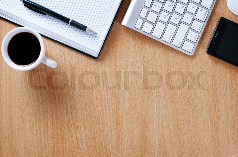 Close up Wooden Table of Businessman with Notebook and Pen, Computer Keyboard, Mobile Phone and A Cup of Black Coffee to Stay as Stress Reliever, stock photo
