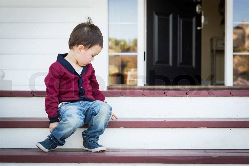Cute Melancholy Mixed Race Boy Sitting on Front Porch Steps, stock photo