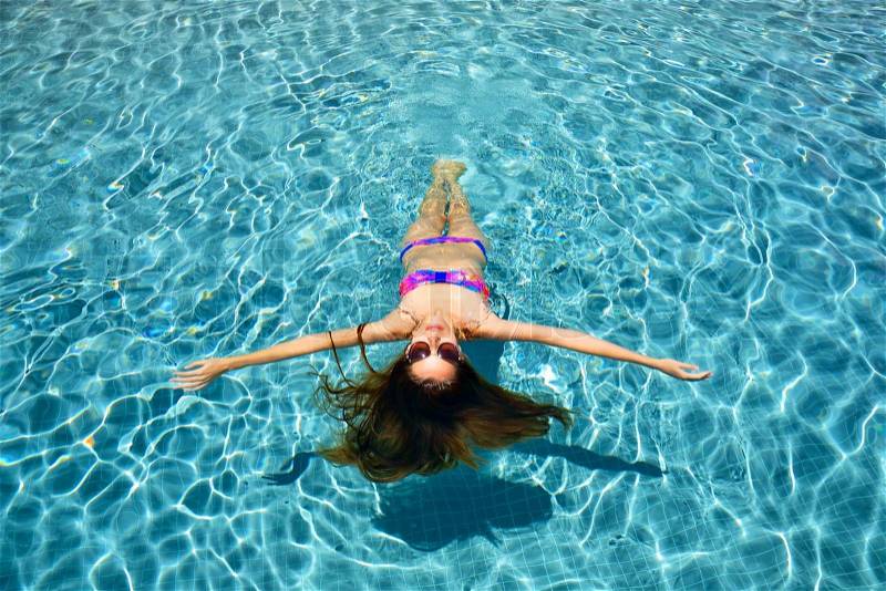 Female beauty relaxing in swimming pool, top view, stock photo
