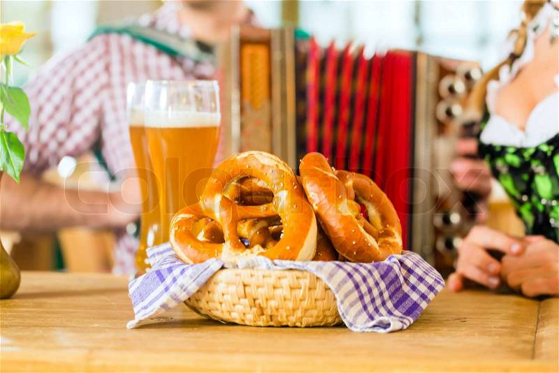 Bavarian restaurant with music, guests, wheat beer and pretzels, stock photo
