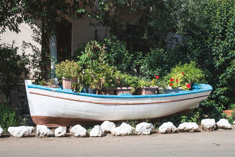 Old boat on land and flowers, stock photo