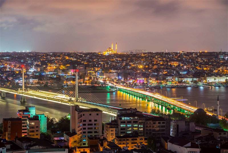 ISTANBUL - SEPTEMBER 17, 2014: City night panorama with New Galata Bridge and Ataturk Bridge on background. Istanbul is visited by more than 11 million people every year, stock photo